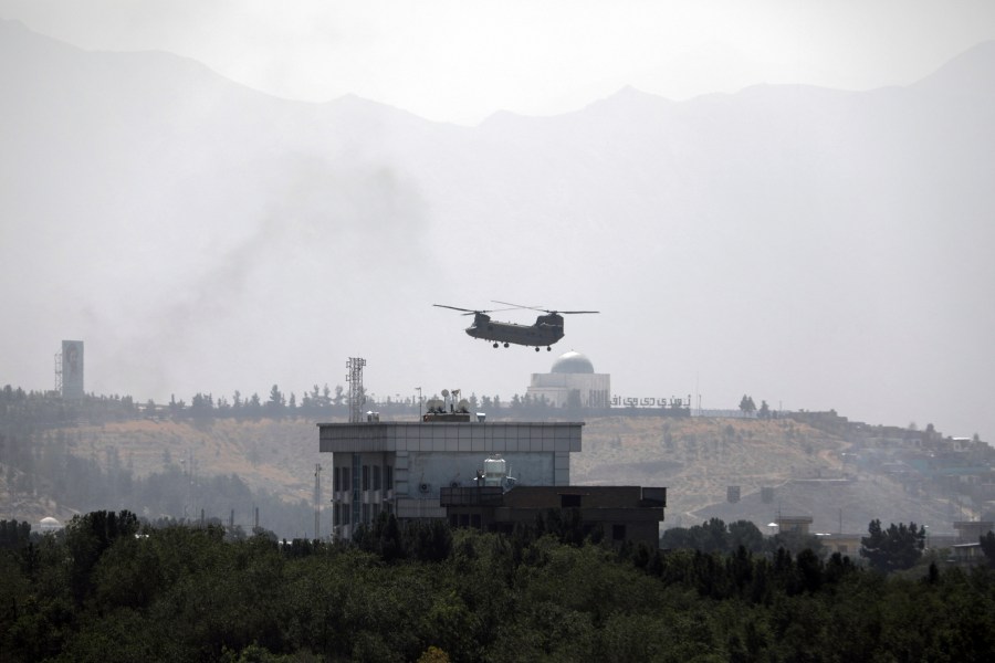 A U.S. Chinook helicopter flies over the U.S. Embassy in Kabul, Afghanistan, Sunday, Aug. 15, 2021. Helicopters are landing at the U.S. Embassy in Kabul as diplomatic vehicles leave the compound amid the Taliban advanced on the Afghan capital. (AP Photo/Rahmat Gul)