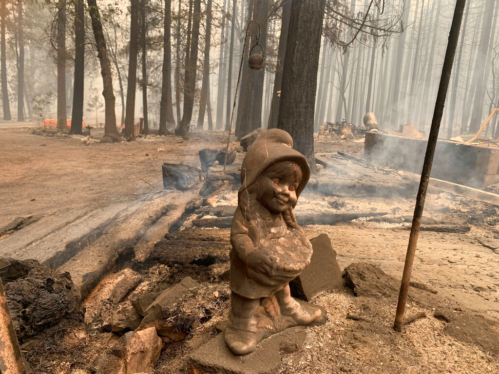 A surviving ceramic statue is seen outside a house that burned along North Arm Road in Plumas County near Taylorsville, Calif., Sunday, Aug. 15, 2021. (AP Photo/Eugene Garcia)