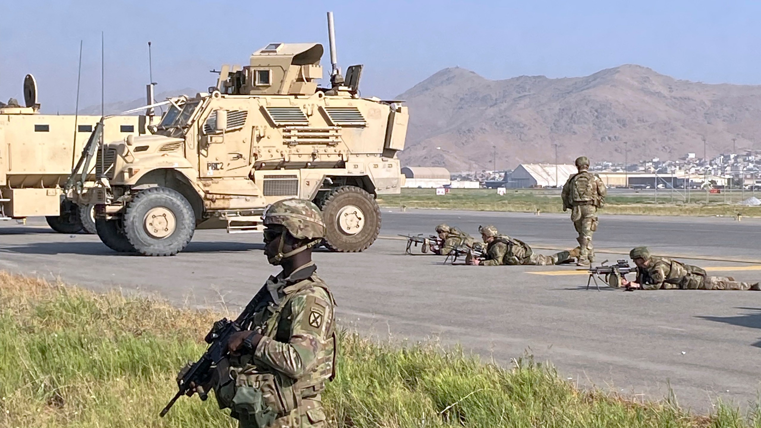 U.S soldiers stand guard along a perimeter at the international airport in Kabul, Afghanistan, Monday, Aug. 16, 2021. On Monday, the U.S. military and officials focus was on Kabul's airport, where thousands of Afghans trapped by the sudden Taliban takeover rushed the tarmac and clung to U.S. military planes deployed to fly out staffers of the U.S. Embassy, which shut down Sunday, and others. (AP Photo/Shekib Rahmani)