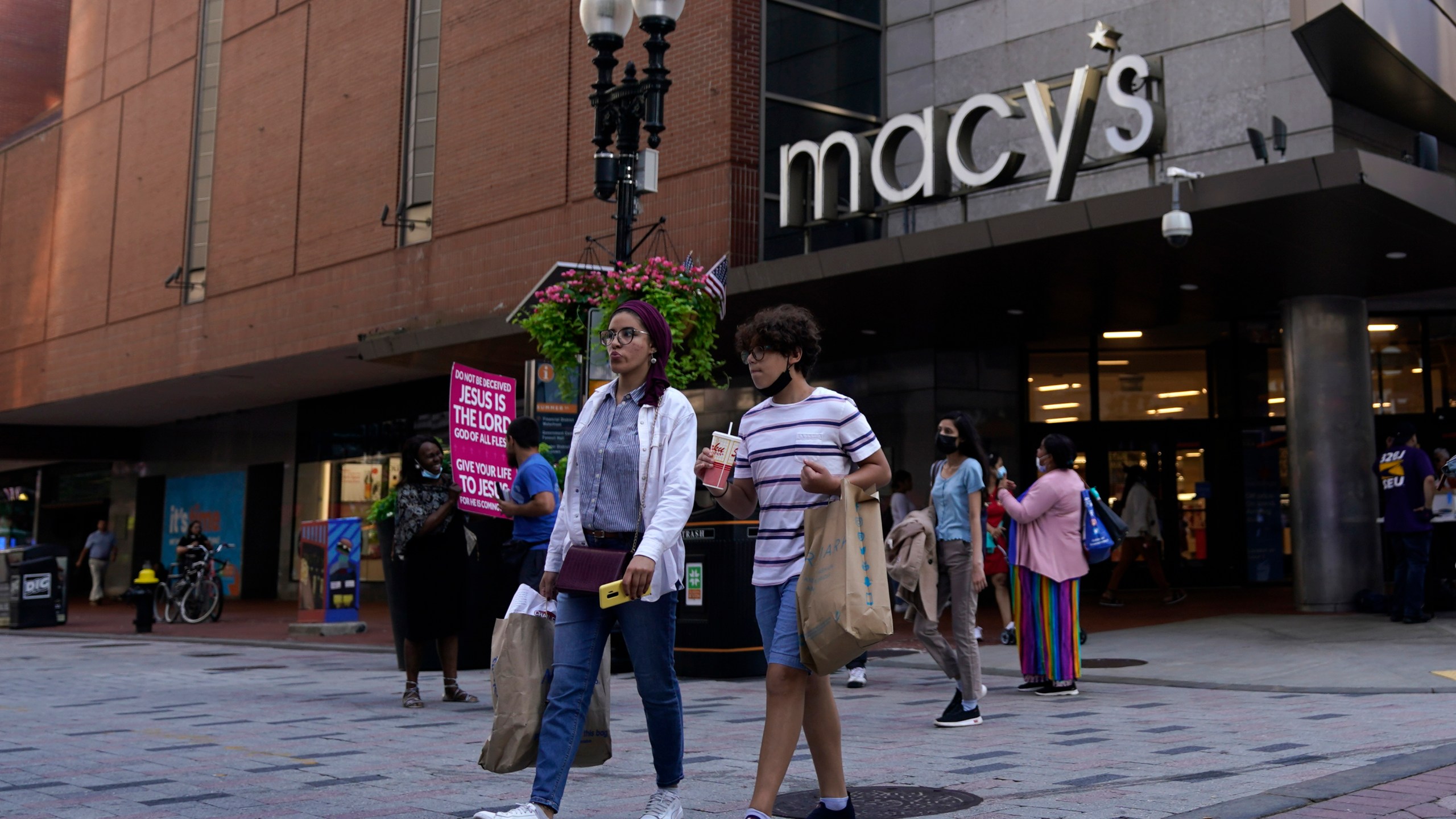 In this July 14, 2021 file photo, pedestrians pass the Macy's store in the Downtown Crossing shopping area, in Boston. (AP Photo/Charles Krupa, File)