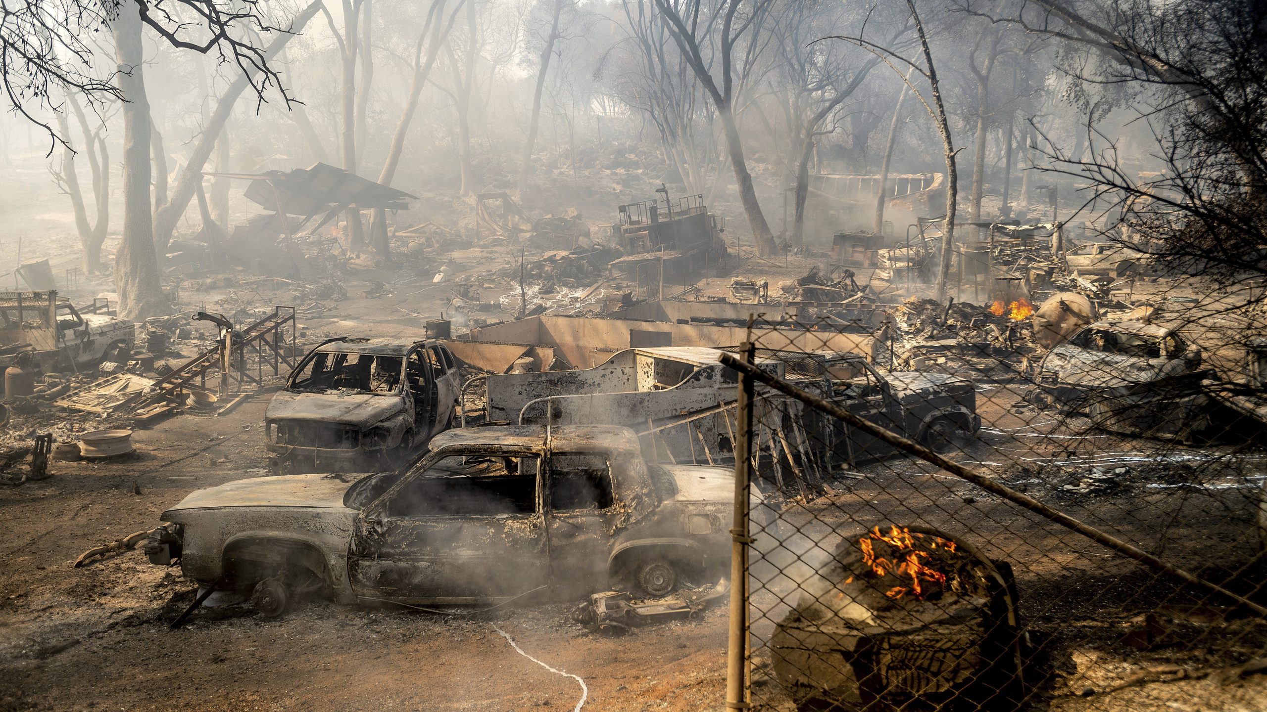 Scorched cars line a property as the Cache Fire burns in Clearlake, Calif., on Aug. 18, 2021. The fire destroyed dozens of homes. (Noah Berger / Associated Press)