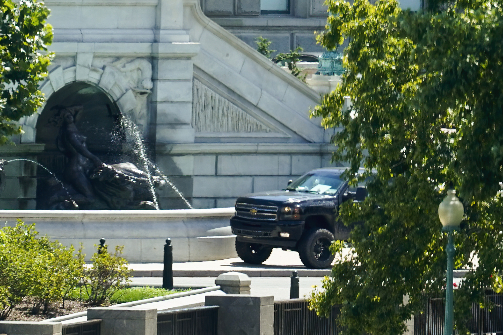 A pickup truck is parked on the sidewalk in front of the Library of Congress' Thomas Jefferson Building, as seen from a window of the U.S. Capitol, Thursday, Aug. 19, 2021, in Washington. A man sitting in the pickup truck outside the Library of Congress has told police that he has a bomb, and that's led to a massive law enforcement response to determine whether it's an operable explosive device. (AP Photo/Alex Brandon)