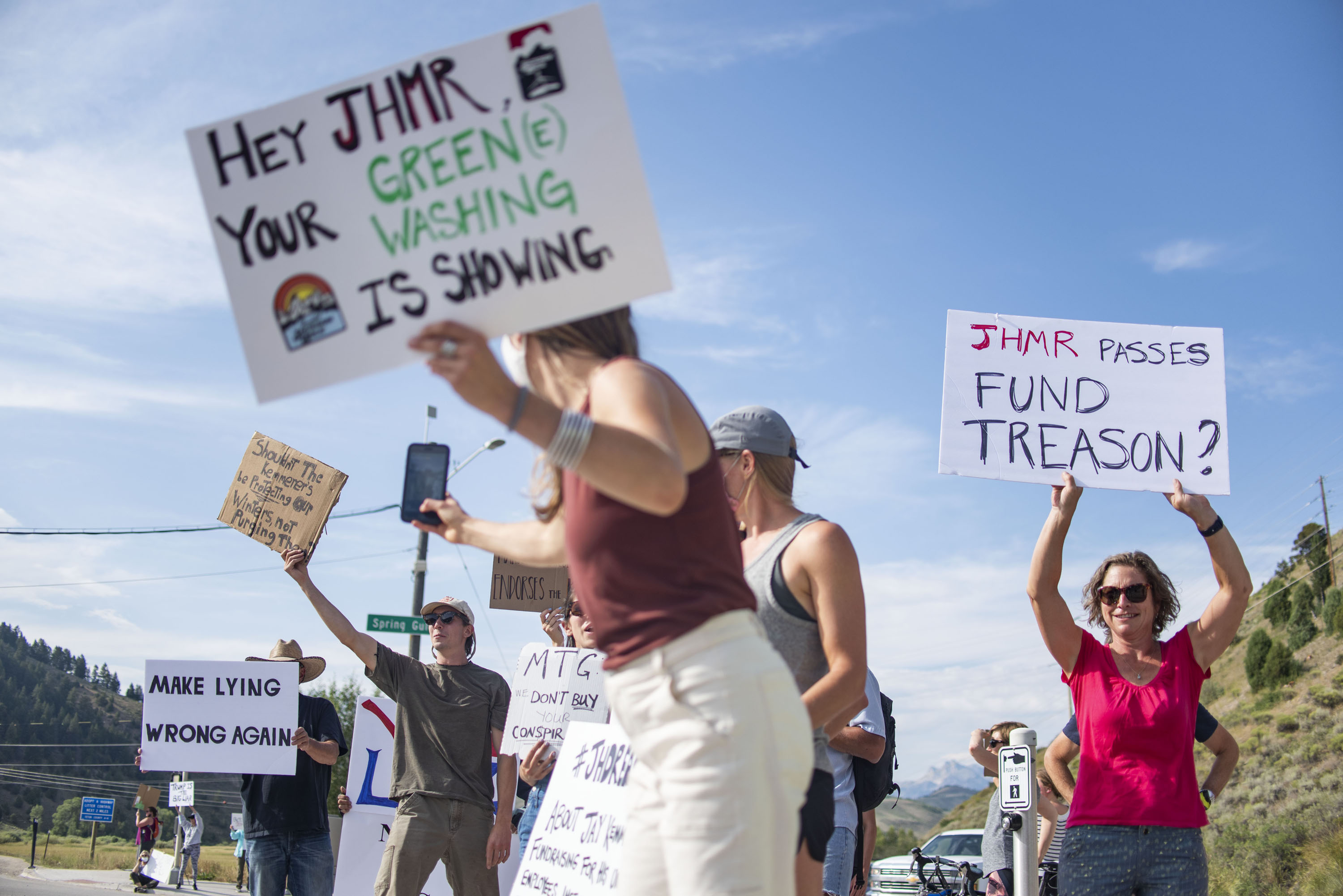 In this Aug. 5, 2021, photo Nikki Kaufman takes a photo of a fellow demonstrator while protesting Jackson Hole Mountain Resort owner Jay Kemmerer's decision to co-host a fundraiser for the House Freedom Fund near Jackson, Wyo. Kaufman and others have called on others to think critically about their ski pass purchases. The outdoor gear and clothing company Patagonia has stopped providing its merchandise for sale at a Wyoming ski resort to protest the owners' sponsorship of a Republican fundraiser featuring Marjorie Taylor Greene and other core supporters of former President Donald Trump. (Meg Potter/Jackson Hole News & Guide via AP)