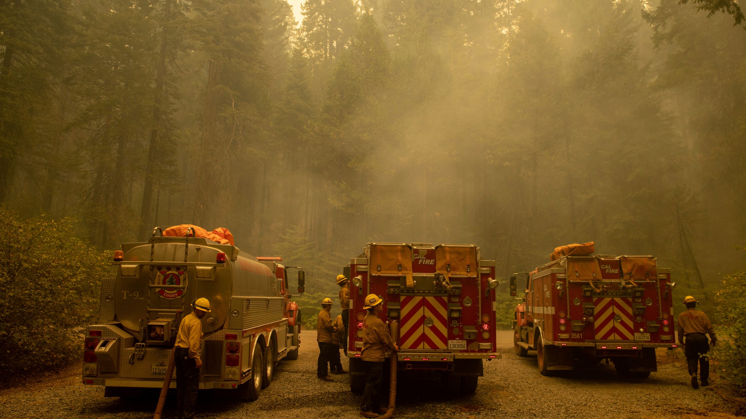 Firefighters refill water while fighting the Caldor Fire on Hazel Valley Road east of Riverton, Calif., on Thursday, Aug. 19, 2021. (AP Photo/Ethan Swope)