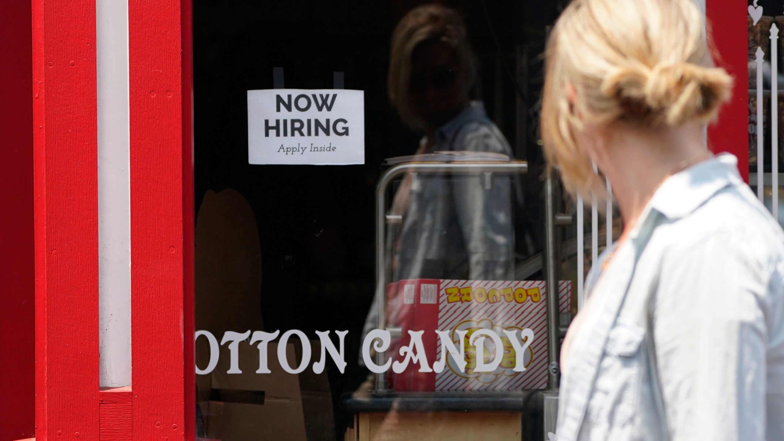 A "NOW HIRING" sign is posted in the window of The Wharf Chocolate Factory at Fisherman's Wharf in Monterey on Aug. 6, 2021. (Rich Pedroncelli / Associated Press)