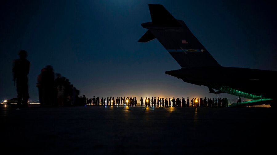 In this image provided by the U.S. Air Force, U.S. Air Force aircrew, assigned to the 816th Expeditionary Airlift Squadron, prepare to load qualified evacuees aboard a U.S. Air Force C-17 Globemaster III aircraft in support of the Afghanistan evacuation at Hamid Karzai International Airport, Kabul, Afghanistan, Saturday, Aug. 21, 2021. (Senior Airman Taylor Crul/U.S. Air Force via AP)