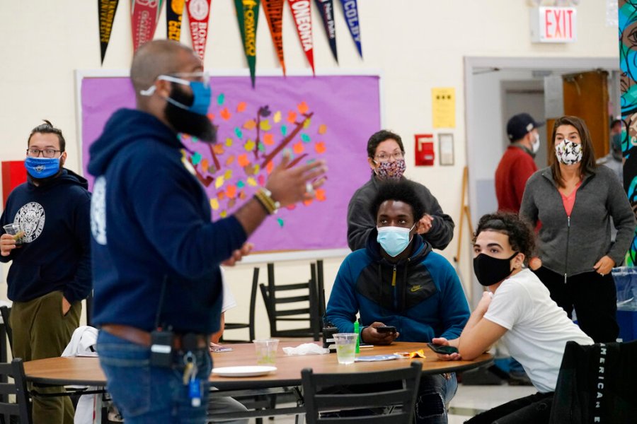 In this Oct. 29, 2020, file photo, students, teachers, administrators and counselors listen as principal Malik Lewis, second from left, teaches them a history lesson at West Brooklyn Community High School in New York. (AP Photo/Kathy Willens, File)