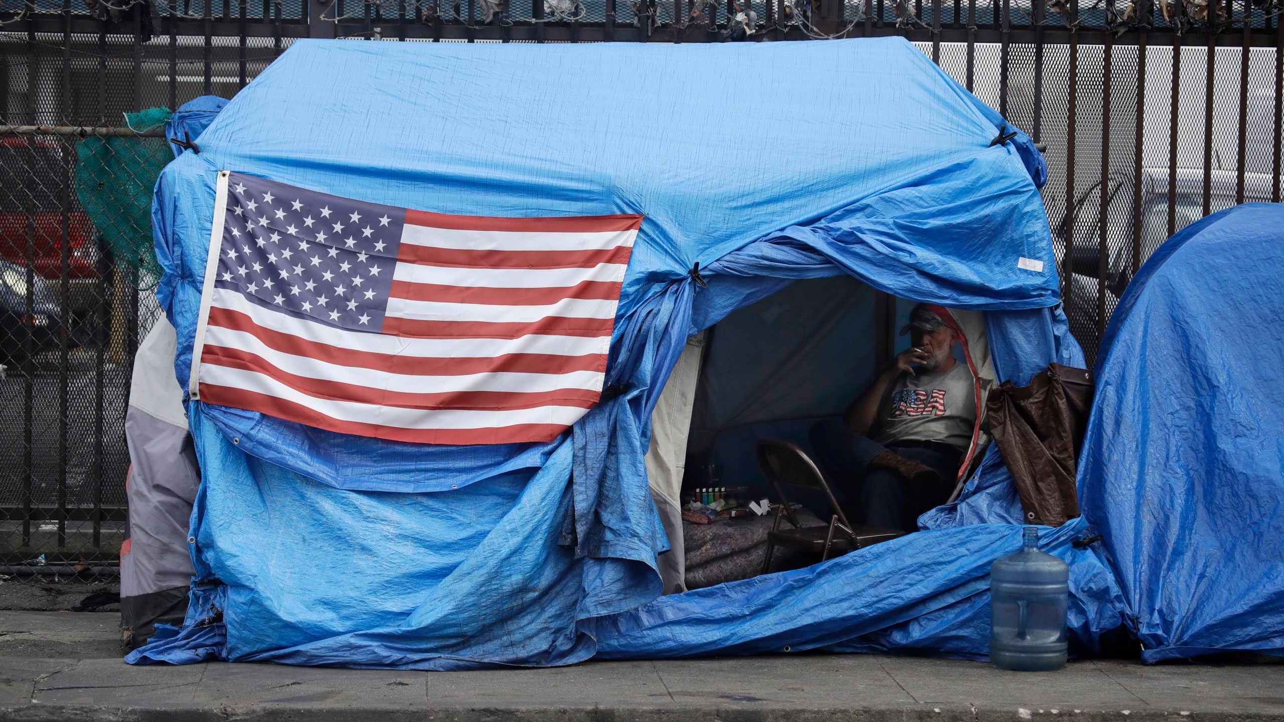 A man smokes inside a tent on skid row in Los Angeles on March 20, 2020. (Marcio Jose Sanchez / Associated Press)