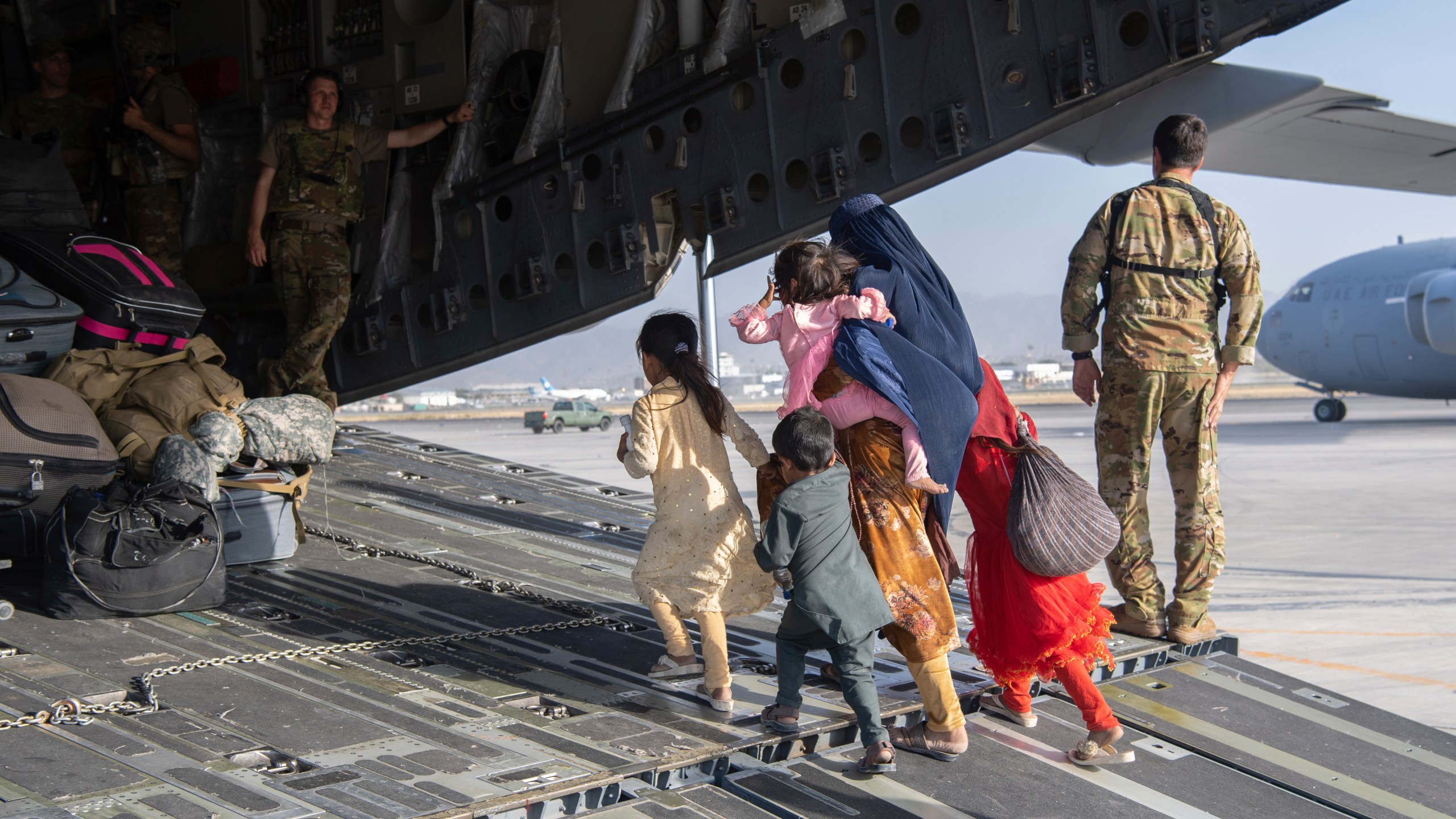 In this image provided by the U.S. Air Force, U.S. Air Force loadmasters and pilots assigned to the 816th Expeditionary Airlift Squadron, load people being evacuated from Afghanistan onto a U.S. Air Force C-17 Globemaster III at Hamid Karzai International Airport in Kabul, Afghanistan, Tuesday, Aug. 24, 2021. (Master Sgt. Donald R. Allen/U.S. Air Force via AP)