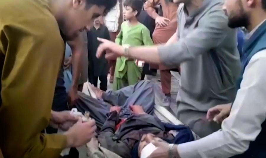 In this frame grab from video, people attend to a wounded man near the site of a deadly explosion outside the airport in Kabul, Afghanistan, Thursday, Aug. 26, 2021. Two suicide bombers and gunmen have targeted crowds massing near the Kabul airport, in the waning days of a massive airlift that has drawn thousands of people seeking to flee the Taliban takeover of Afghanistan. (AP Photo)