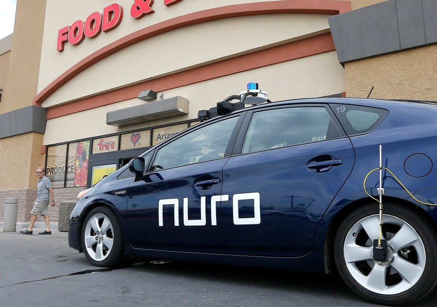 In this Aug. 16, 2018, file photo, a self-driving Nuro vehicle parks outside a Fry's supermarket, which is owned by Kroger, as part of a pilot program for grocery deliveries in Scottsdale, Ariz. Nuro, the robotics company that develops driverless vehicles for on-road grocery, pizza and prescription deliveries said Thursday, Aug. 26, 2021, it intends to spend $40 million to put a manufacturing facility at the Las Vegas Motor Speedway. (AP Photo/Ross D. Franklin, File)