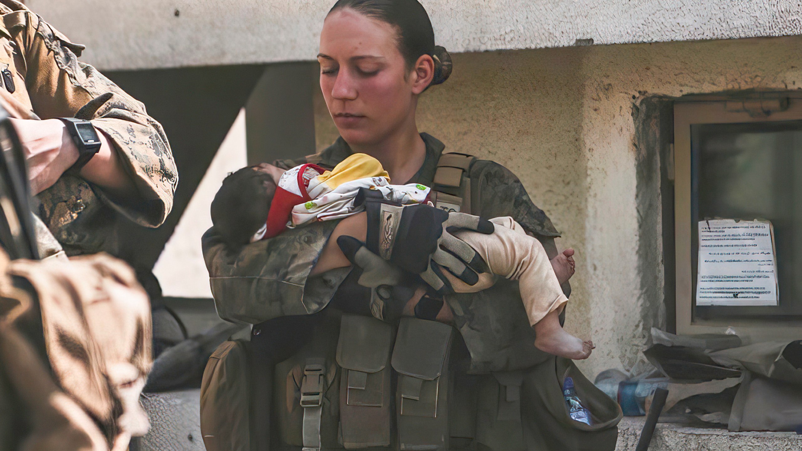 In this Aug. 20, 2021, image provided by the U.S. Marine Corps, Marines assigned to the 24th Marine Expeditionary Unit (MEU), including Sgt. Nicole Gee calms an infant during an evacuation at Hamid Karzai International Airport in Kabul, Afghanistan. Officials said Aug. 28, that Gee of Sacramento, Calif., was one of the Marines killed in Thursday's bombing at the airport. (Sgt. Isaiah Campbell/U.S. Marine Corps via AP)