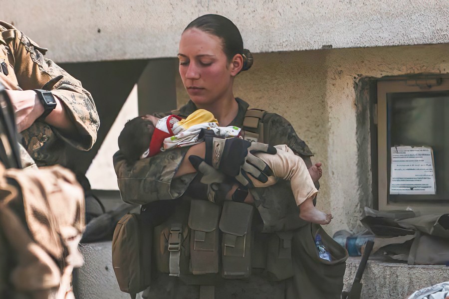 In this Aug. 20, 2021, image provided by the U.S. Marine Corps, Marines assigned to the 24th Marine Expeditionary Unit (MEU), including Sgt. Nicole Gee calms an infant during an evacuation at Hamid Karzai International Airport in Kabul, Afghanistan. Officials said Aug. 28, that Gee of Sacramento, Calif., was one of the Marines killed in Thursday's bombing at the airport. (Sgt. Isaiah Campbell/U.S. Marine Corps via AP)