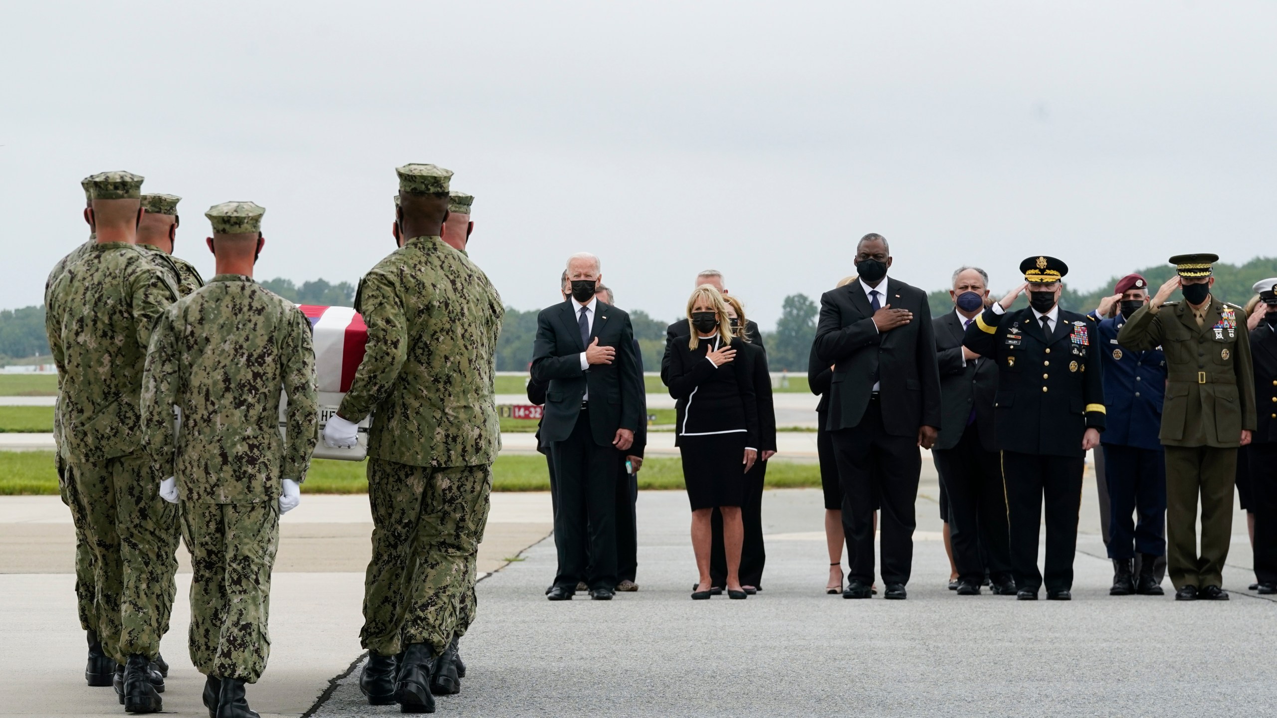 President Joe Biden watches as a Navy carry team moves a transfer case containing the remains of Navy Corpsman Maxton W. Soviak, 22, of Berlin Heights, Ohio, Sunday, Aug. 29, 2021, at Dover Air Force Base, Del. According to the Department of Defense, Soviak died in an attack at Afghanistan's Kabul airport, along with 12 other U.S. service members supporting Operation Freedom's Sentinel. From left, President Joe Biden, first lady Jill Biden, Secretary of Defense Lloyd Austin, and Joint Chiefs Chairman Gen. Mark Milley. (AP Photo/Manuel Balce Ceneta)