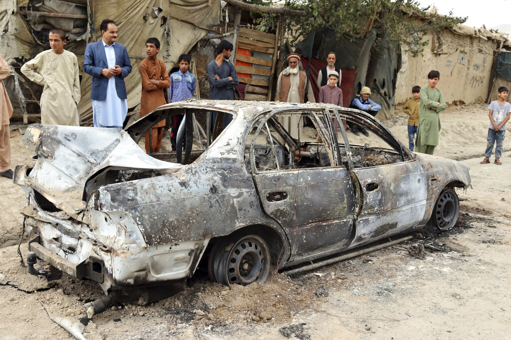 Locals view a vehicle damaged by a rocket attack in Kabul, Afghanistan, Monday, Aug. 30, 2021. Rockets struck a neighborhood near Kabul's international airport on Monday amid the ongoing U.S. withdrawal from Afghanistan. (AP Photo/Khwaja Tawfiq Sediqi)