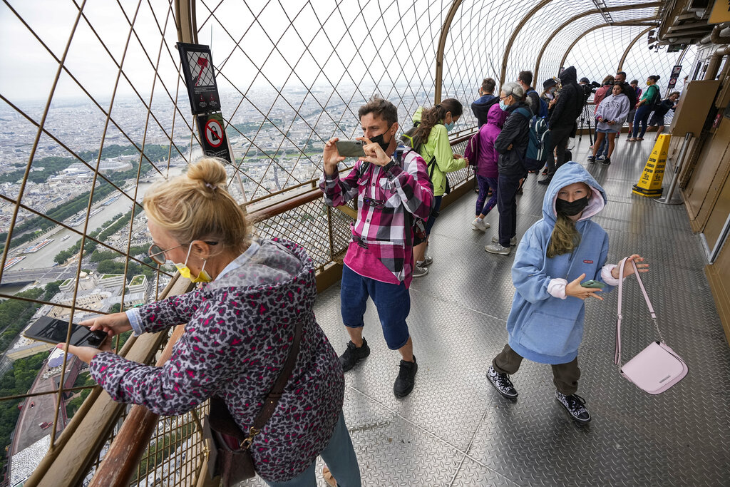 In this Friday, July 16, 2021 file photo, visitors enjoy the view from top of the Eiffel Tower in Paris. (AP Photo/Michel Euler, File)