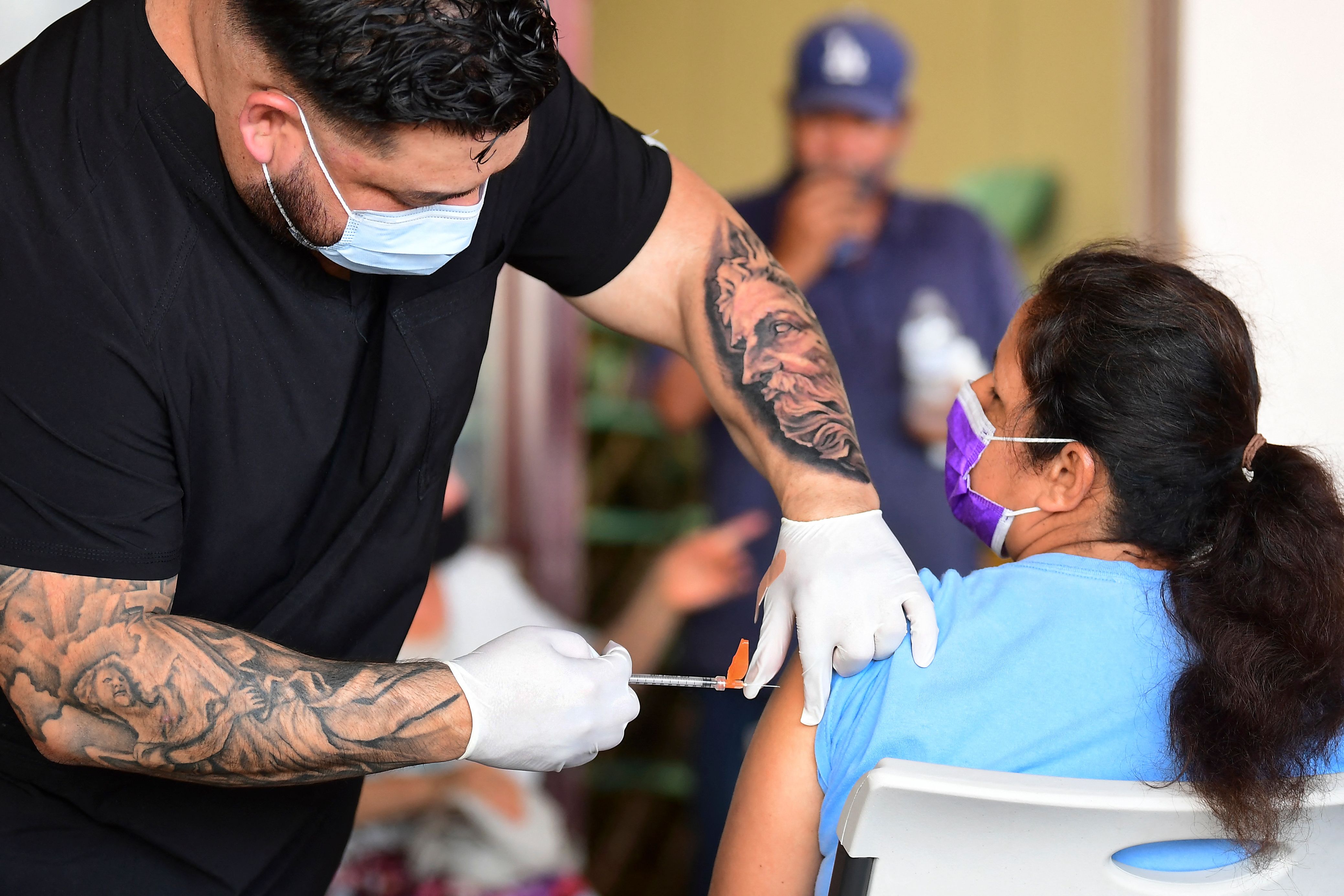 The Pfizer COVID-19 vaccine is administered at a mobile clinic to residents in an East Los Angeles neighborhood. (FREDERIC J. BROWN/AFP via Getty Images)