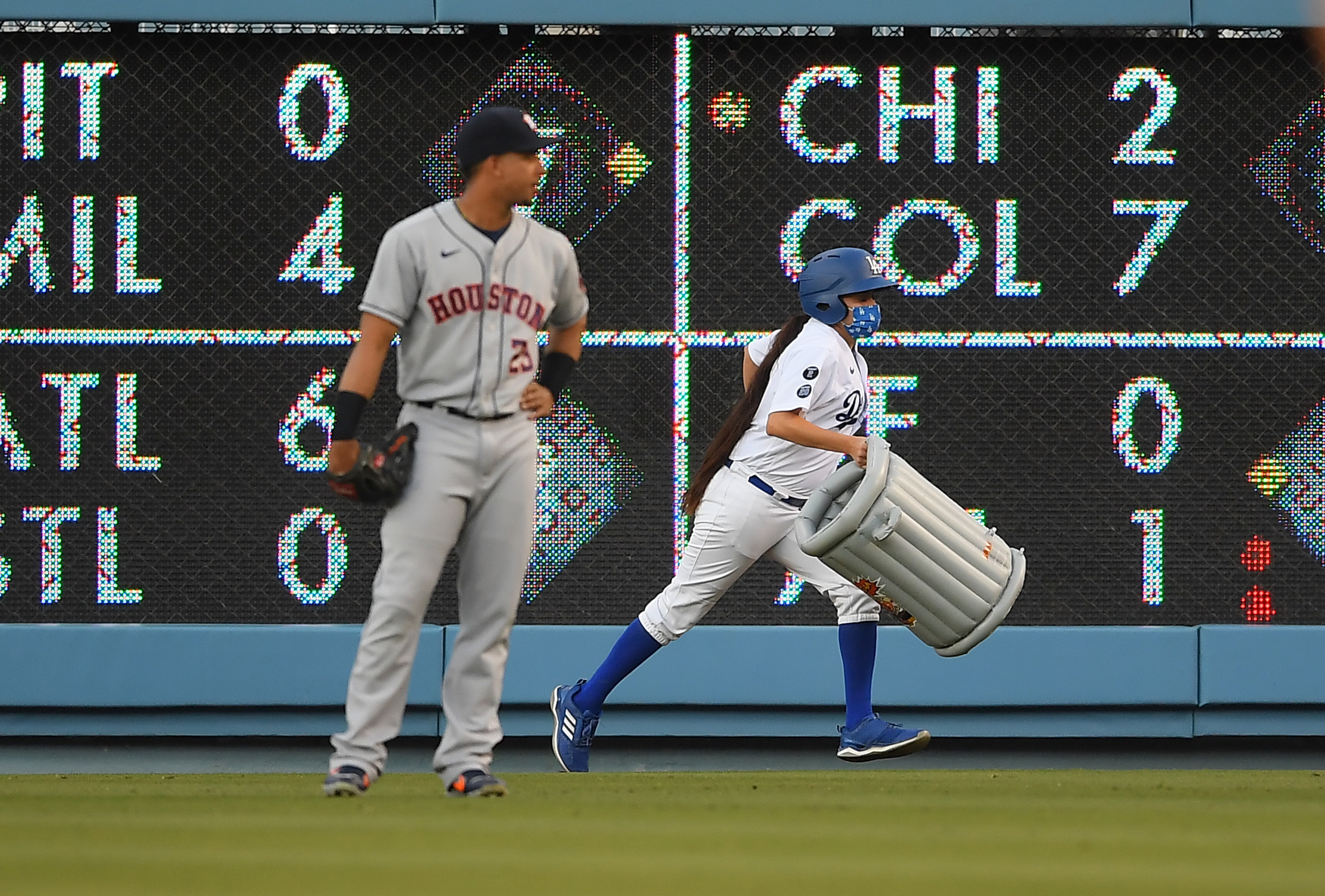 Michael Brantley #23 of the Houston Astros watches as a bat girl removes an inflatable trash can that was thrown onto the field in the first inning against the Los Angeles Dodgers at Dodger Stadium on Aug. 3, 2021, in Los Angeles, California. (Jayne Kamin-Oncea/Getty Images)