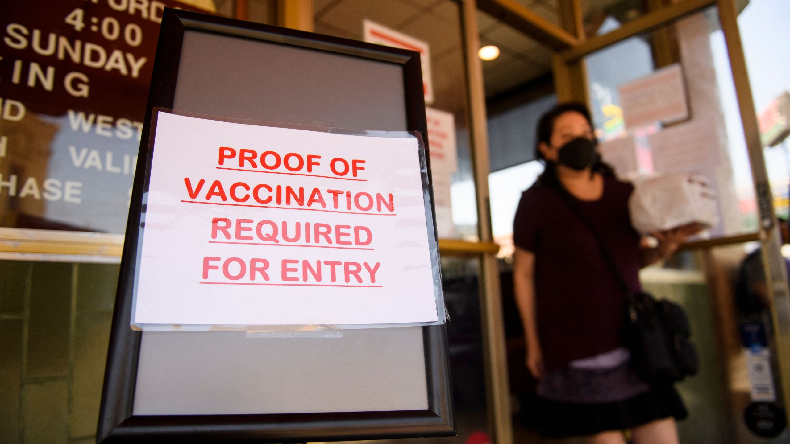 A sign saying that proof of COVID-19 vaccination is required is displayed outside of Langer's Deli in Los Angeles on Aug. 7, 2021. (PATRICK T. FALLON/AFP via Getty Images)