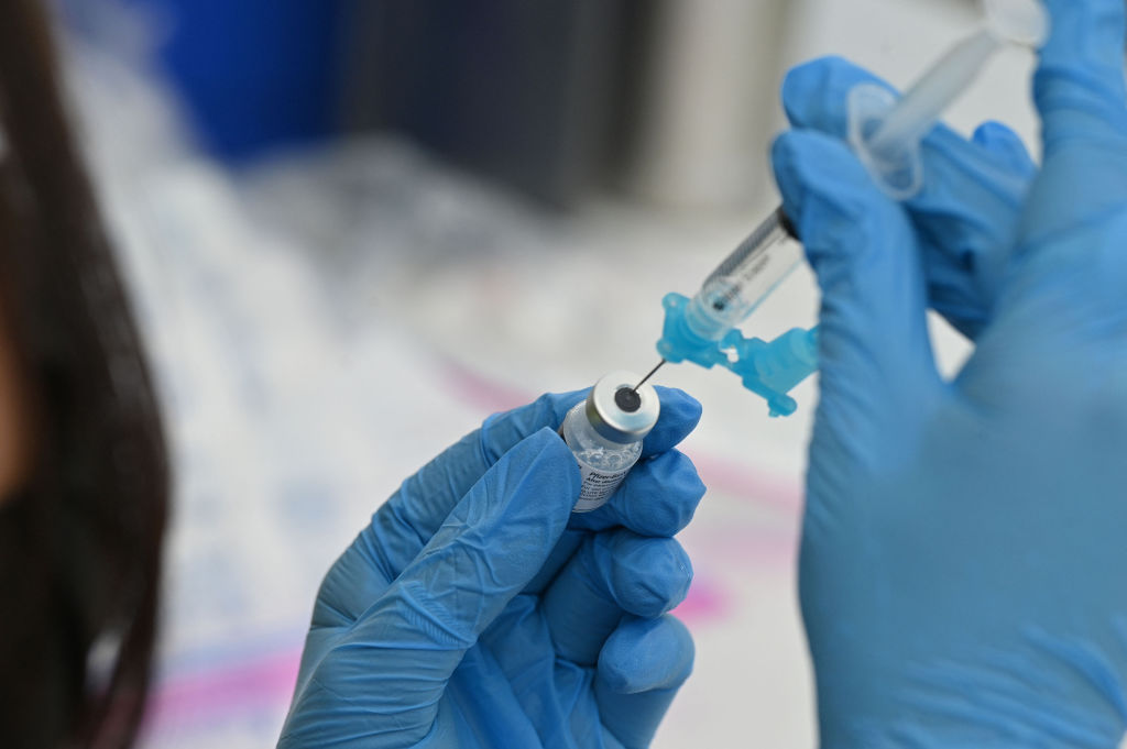 A healthcare worker fills a syringe with the Pfizer COVID-19 vaccine at a community vaccination event in a predominately Latino neighborhood in Los Angeles, California, on Aug. 11, 2021. (ROBYN BECK/AFP via Getty Images)