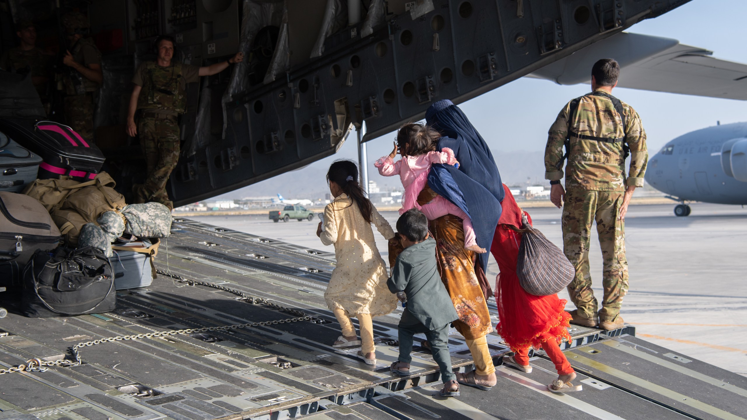 In this handout provided by U.S. Central Command Public Affairs, U.S. Air Force loadmasters and pilots assigned to the 816th Expeditionary Airlift Squadron, load passengers aboard a U.S. Air Force C-17 Globemaster III in support of the Afghanistan evacuation at Hamid Karzai International Airport in Kabul, Afghanistan, on Aug. 24, 2021. (Master Sgt. Donald R. Allen / U.S. Air Forces Europe-Africa via Getty Images)