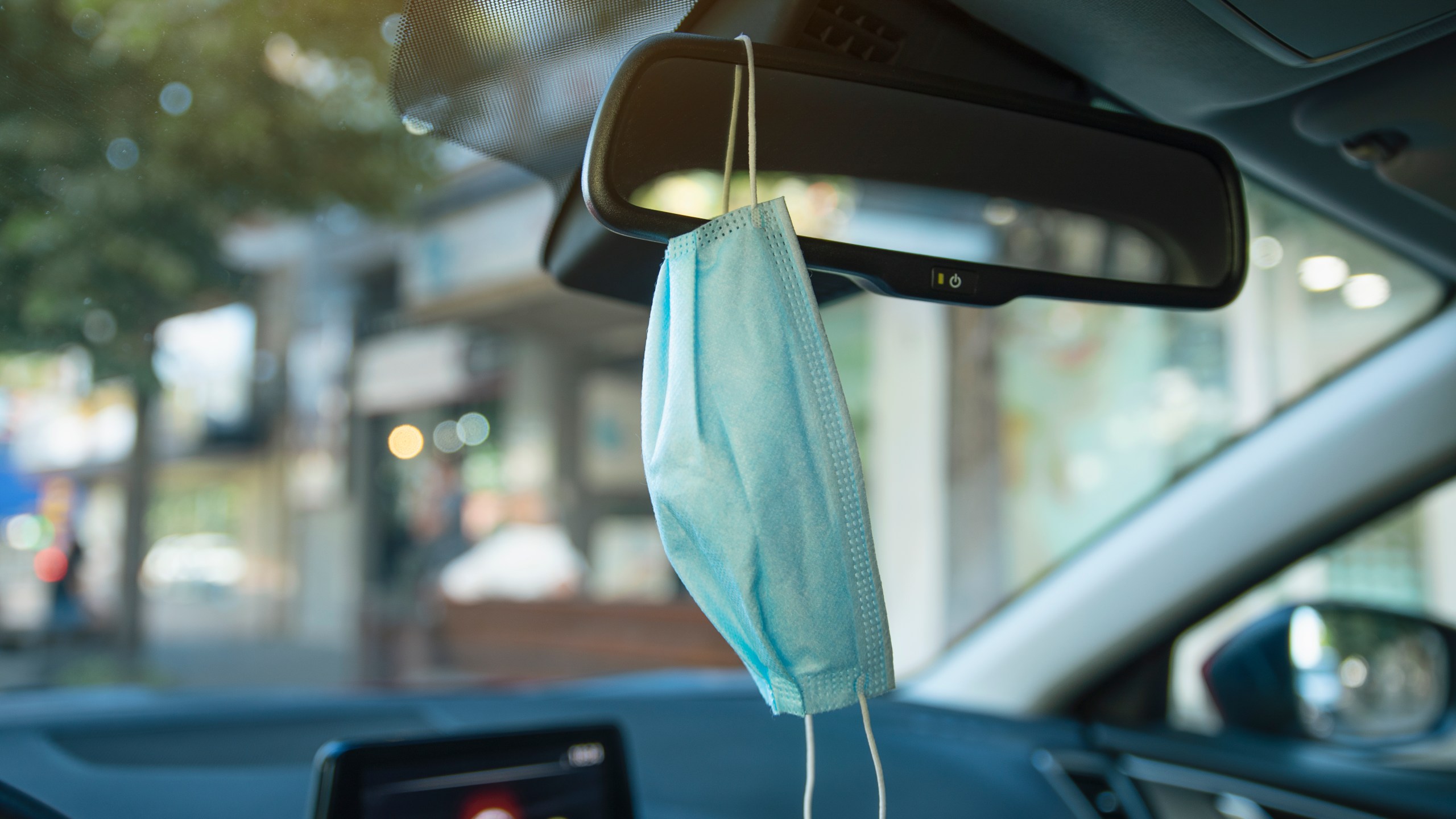 A mask is seen hanging from the interior rearview mirror of a car, in Brussels on Jan. 12, 2021. (LAURIE DIEFFEMBACQ/BELGA MAG/AFP via Getty Images)