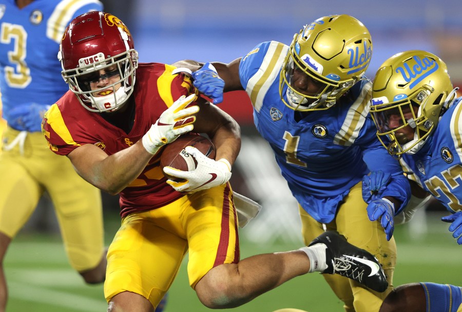 Drake London #15 of the USC Trojans runs past Jay Shaw #1 and Quentin Lake #37 of the UCLA Bruins for a touchdown during the first half of a game at the Rose Bowl on December 12, 2020 in Pasadena. (Sean M. Haffey/Getty Images)