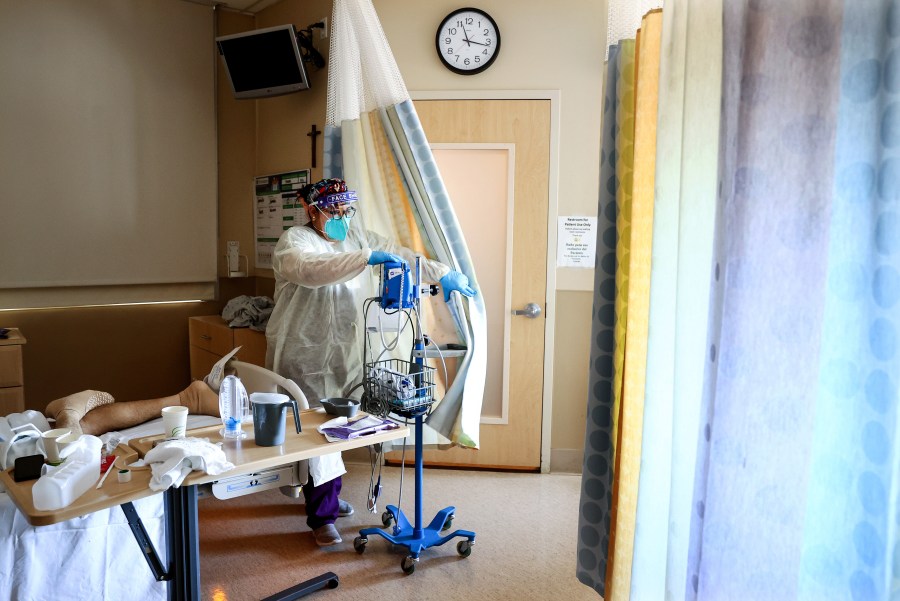 Certified Nursing Assistant (CNA) Paulette Santillan departs after checking a COVID-19 patient's vital signs in the improvised COVID-19 unit at Providence Holy Cross Medical Center in the Mission Hills neighborhood on July 30, 2021 in Los Angeles, California. (Mario Tama/Getty Images)