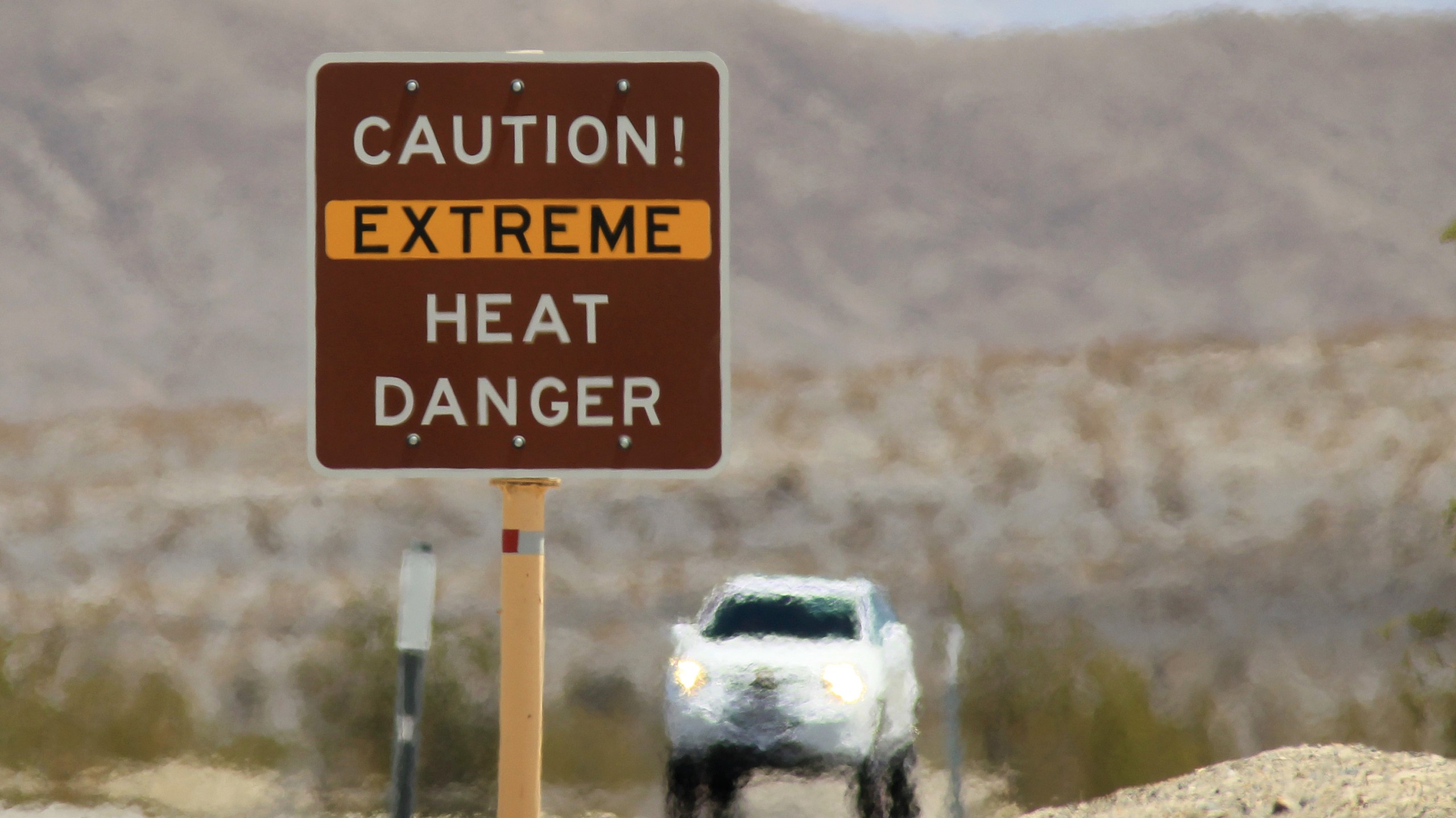 Heat waves rise near a heat danger warning sign on the eve of the AdventurCORPS Badwater 135 ultra-marathon race on July 14, 2013 in Death Valley National Park, California. (David McNew/Getty Images)