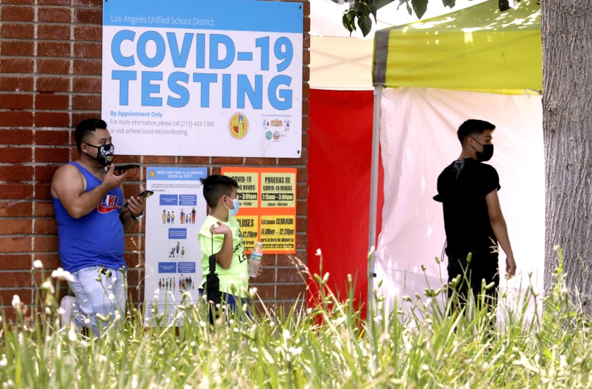 A father waits with his son to be tested for the coronavirus at Northridge Middle School in Northridge in this undated photo. (Genaro Molina/Los Angeles Times)