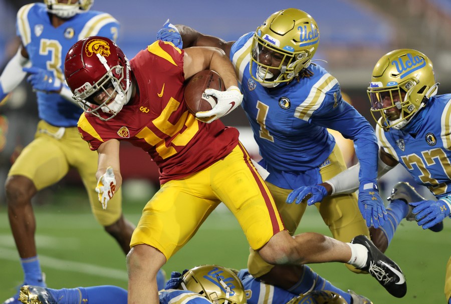 Drake London of the USC Trojans runs past Jay Shaw and Quentin Lake of the UCLA Bruins for a touchdown during the first half of a game at the Rose Bowl on Dec. 12, 2020 in Pasadena, California. (Sean M. Haffey/Getty Images)