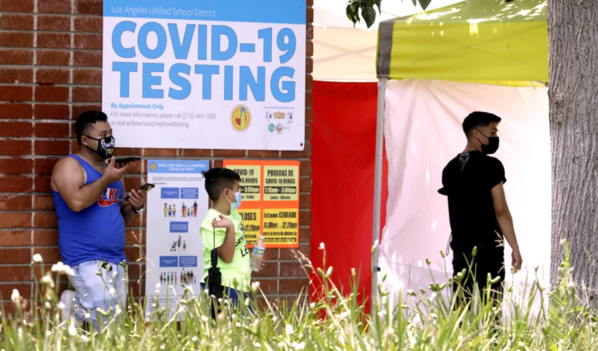 A father waits with his son to be tested for the coronavirus at Northridge Middle School in August 2021.(Genaro Molina / Los Angeles Times)