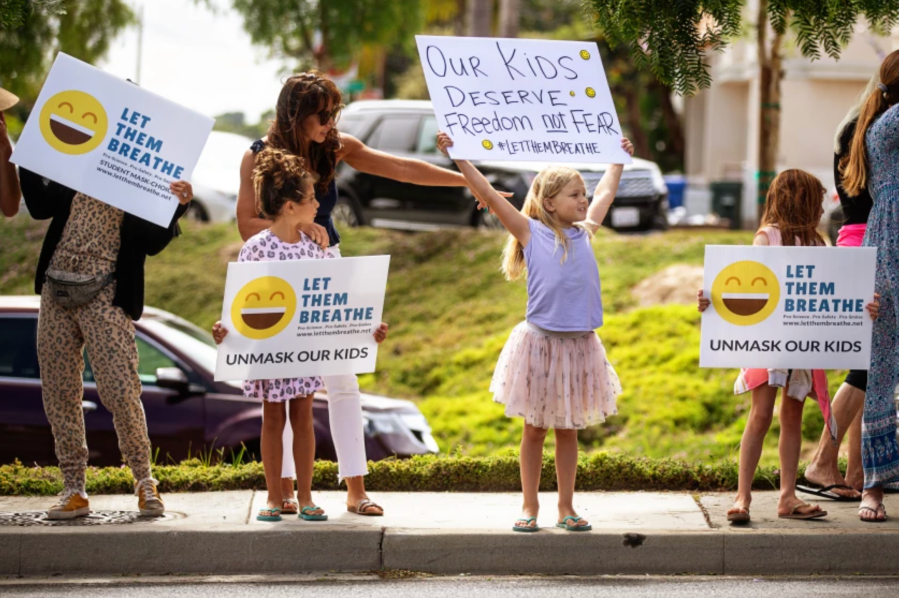 Adults and children with Let Them Breathe, an anti-mask group, protest at the Redondo Beach Unified School District building in July.(Jason Armond / Los Angeles Times)