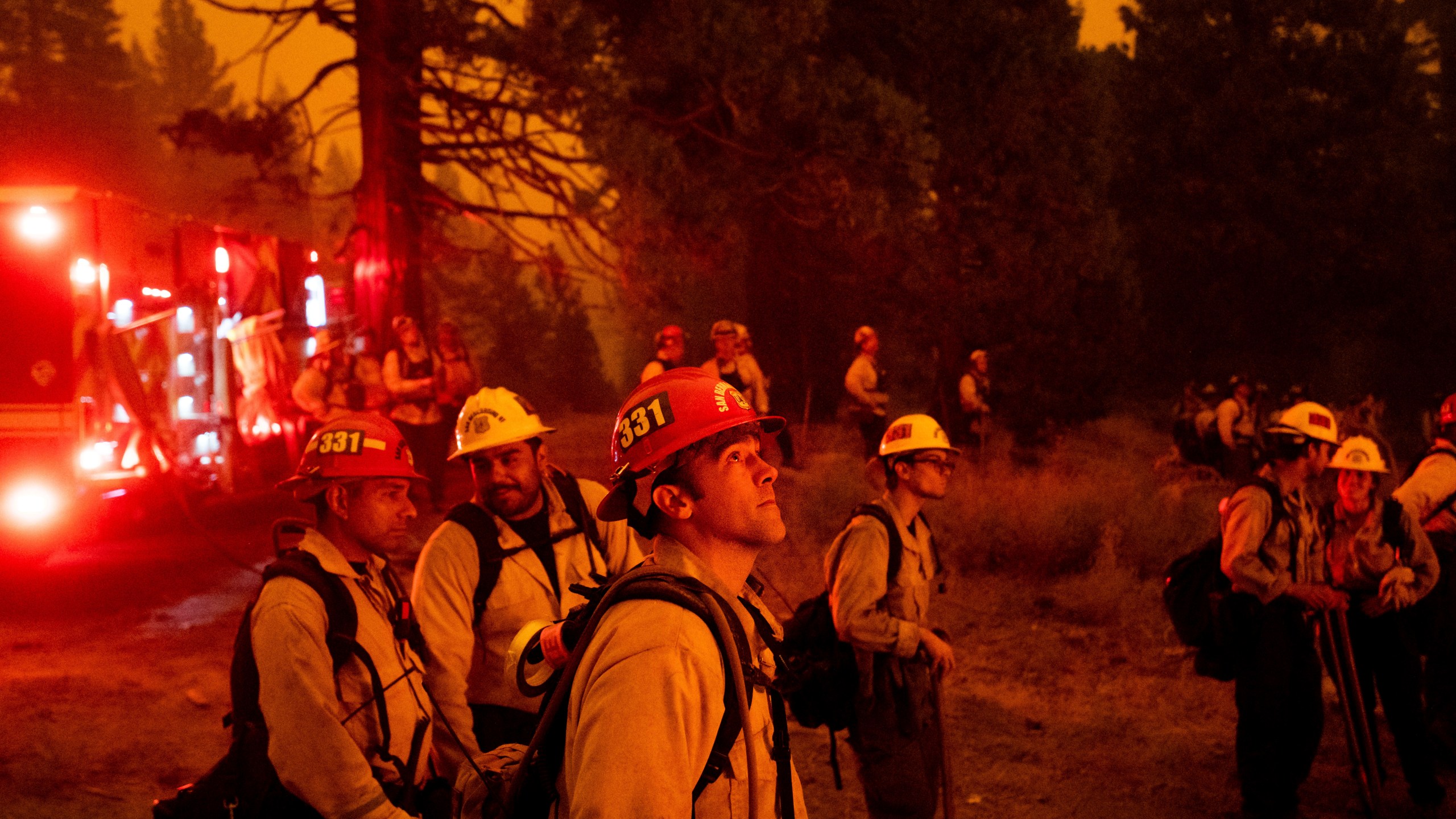 In this Thursday, Aug. 26, 2021 file photo, Capt. Adam Tinker and his crew monitor a firing operation, where crews burn vegetation to create a control line, while battling the Caldor Fire in Eldorado National Forest. (AP Photo/Noah Berger, File)