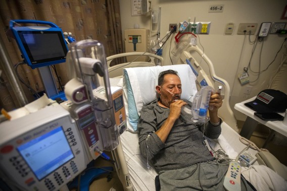 COVID-19 patient Jorge Hernandez, 64, does a lung exercise with his incentive spirometer inside Little Company of Mary Medical Center in Torrance in this undated photo. (Francine Orr/Los Angeles Times)