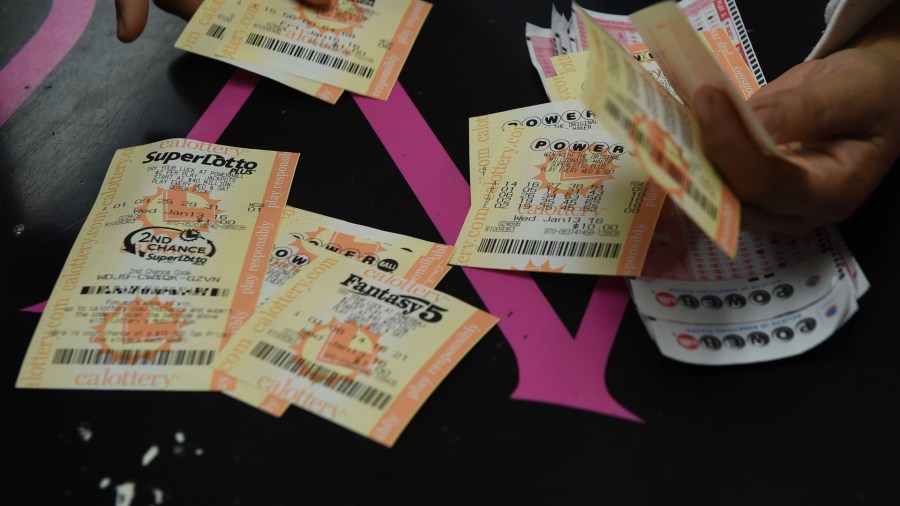 A customer picks lottery tickets at the Bluebird Liquor store in Hawthorne on Jan. 13, 2016. (MARK RALSTON/AFP via Getty Images)