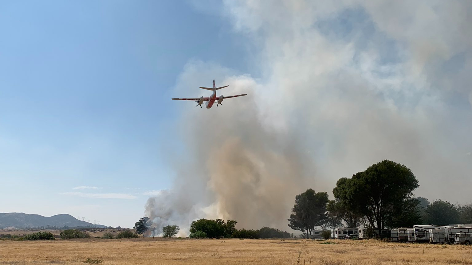 An airplane battles the Westward Fire near Banning High School on Aug. 25, 2021, in a photo provided by Cal Fire Riverside.