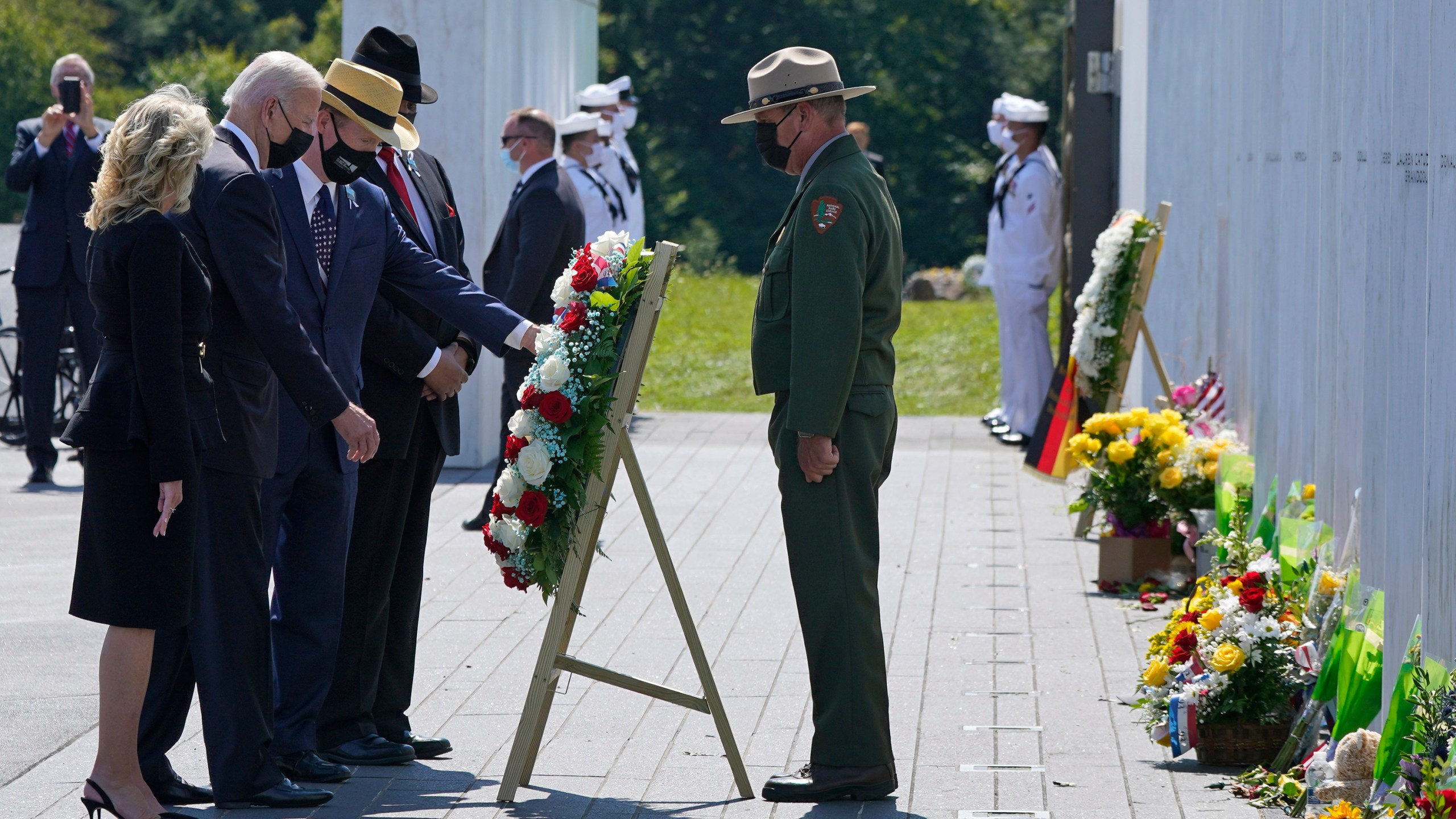 President Joe Biden, second from left, and First Lady Jill Biden, left, help place a wreath at the Wall of Names at the Flight 93 National Memorial with Gordon Felt, third from left, who lost his brother Edward Felt in the crash of Flight 93 in Shanksville, Pa., Saturday, Sept. 11, 2021. (AP Photo/Gene J. Puskar)