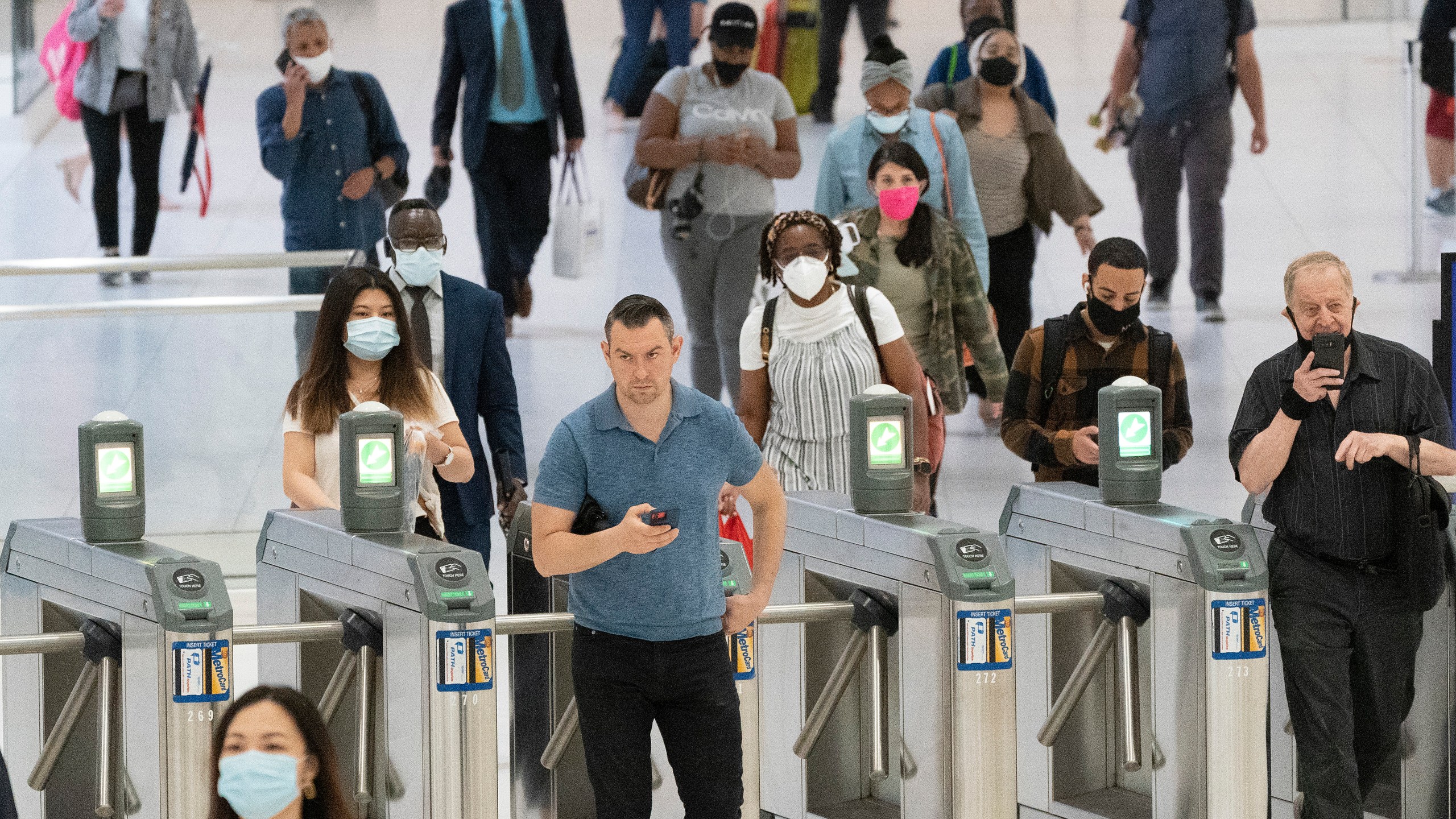 People commute through the World Trade Center, Friday, July 9, 2021, in New York. Businesses that have announced vaccine mandates say some workers who had been on the fence have since gotten inoculated against COVID-19. But many holdouts remain, a likely sign of what is to come once a federal mandate goes into effect. (AP Photo/Mark Lennihan)