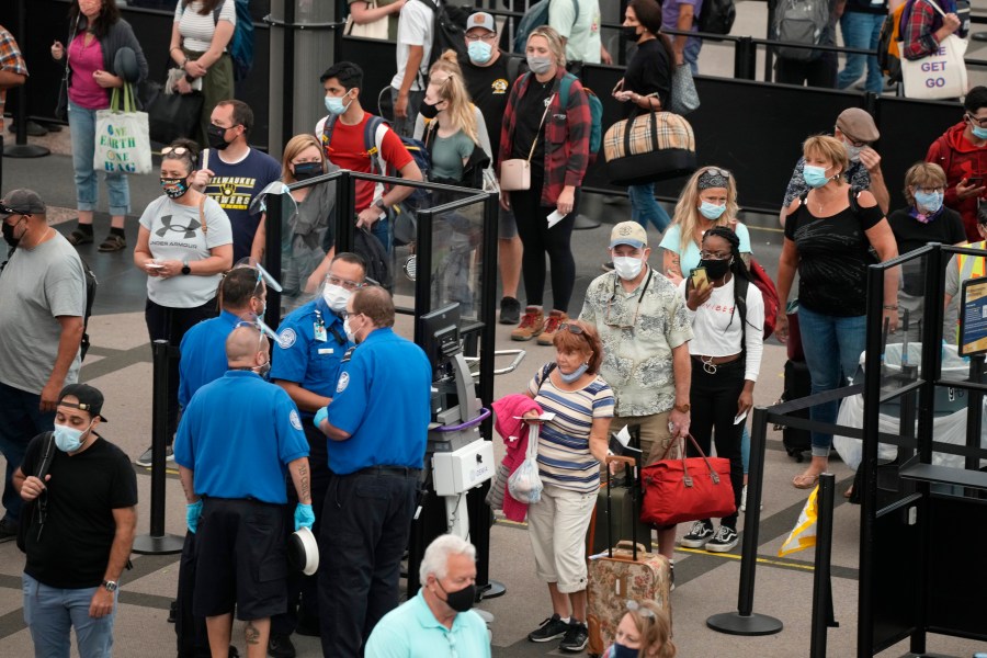 Travelers wear face coverings in the line for the south north security checkpoint in the main terminal of Denver International Airport Tuesday, Aug. 24, 2021, in Denver. Two months after the Sept. 11, 2001 attacks, President George W. Bush signed legislation creating the Transportation Security Administration, a force of federal airport screeners that replaced the private companies that airlines were hiring to handle security. (AP Photo/David Zalubowski)