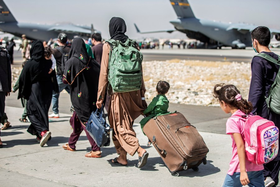 In this Aug. 24, 2021, file photo provided by the U.S. Marine Corps, families walk towards their flight during ongoing evacuations at Hamid Karzai International Airport, in Kabul, Afghanistan. More than 30 California children are stuck in Afghanistan after traveling to the country to see their relatives weeks before the Taliban seized power and US forces left, according to school districts where the kids are enrolled. (Sgt. Samuel Ruiz/U.S. Marine Corps via AP, File)