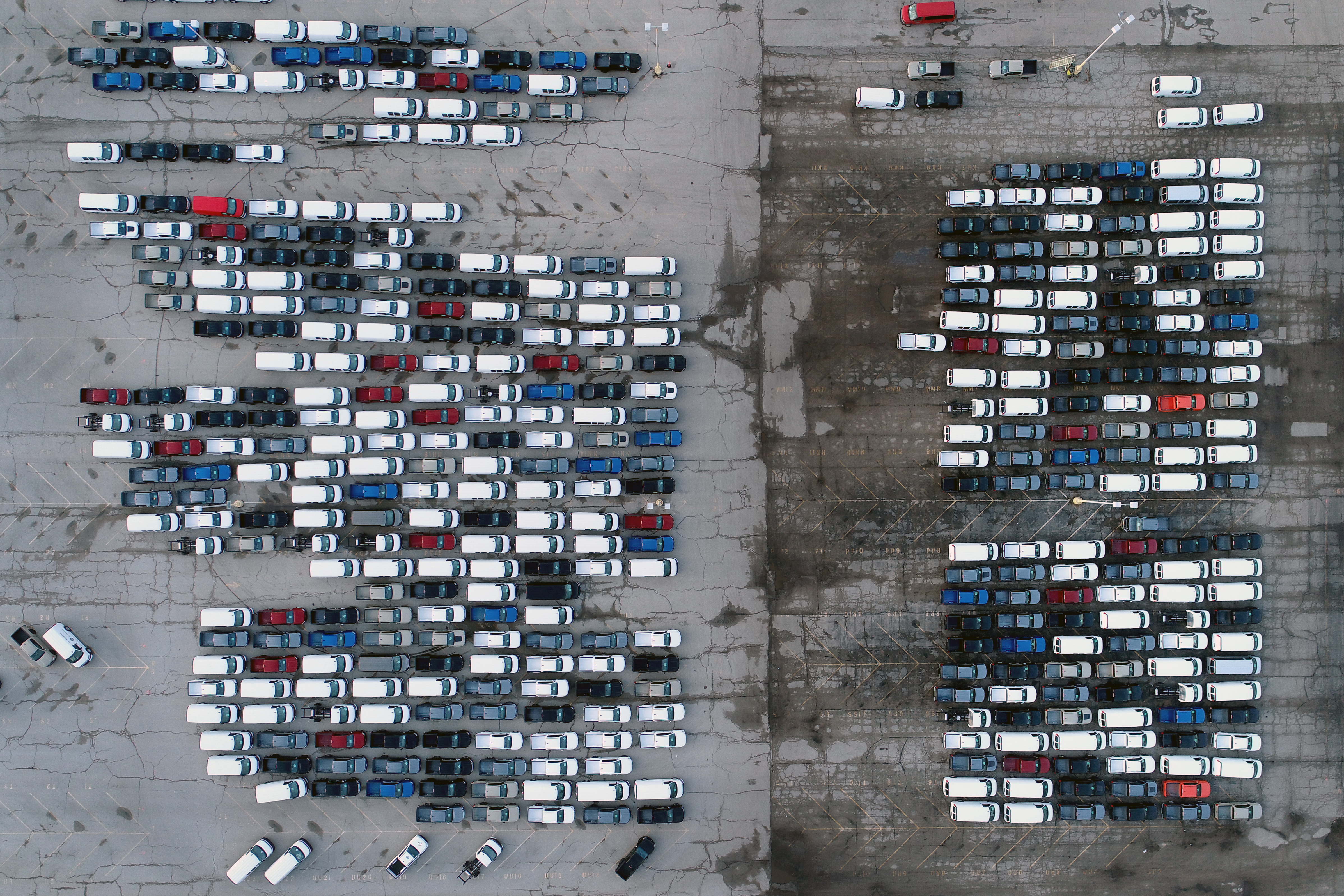 In this March 24, 2021 file photo, mid-sized pickup trucks and full-size vans are seen in a parking lot outside a General Motors assembly plant where they are produced in Wentzville, Mo. The global shortage of computer chips is getting worse, forcing automakers to temporarily close factories including those that build popular pickup trucks. General Motors announced Thursday, Sept, 2, 2021 that it would pause production at seven North American plants during the next two weeks, including two that make the company’s top-selling Chevrolet Silverado pickup. (AP Photo/Jeff Roberson, File)