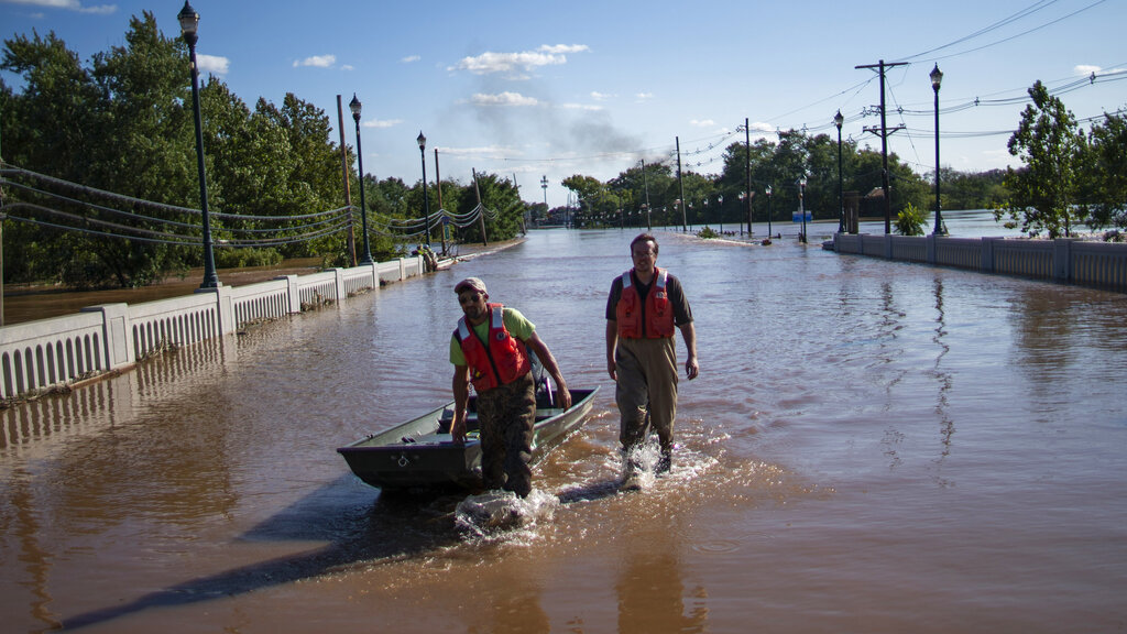 United States Geological Survey workers push a boat as they look for residents on a flooded street along the Raritan River in Somerville, N.J.., Thursday, Sept. 2, 2021. (AP Photo/Eduardo Munoz Alvarez)