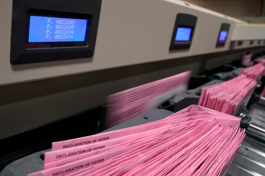 In this Aug. 30, 2021, file photo mail in ballots run through a sorting machine at the Sacramento County Registrar of Voters office in Sacramento, Calif. (AP Photo/Rich Pedroncelli, File)