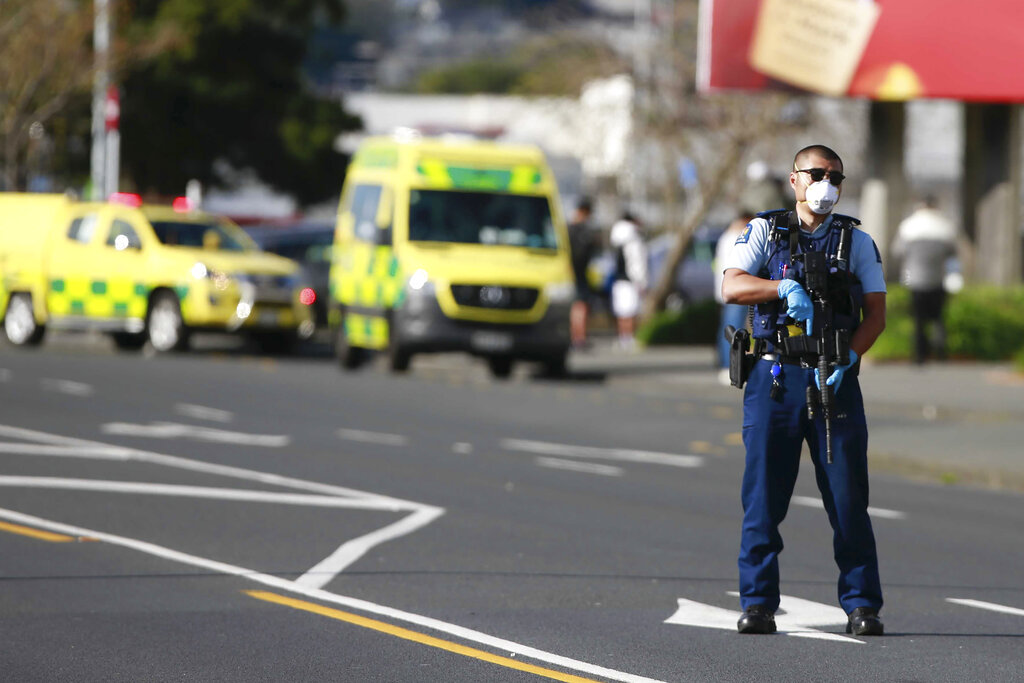 A police officer stands outside an Auckland supermarket, Friday, Sept. 3, 2021. (Alex Burton/New Zealand Herald via AP)