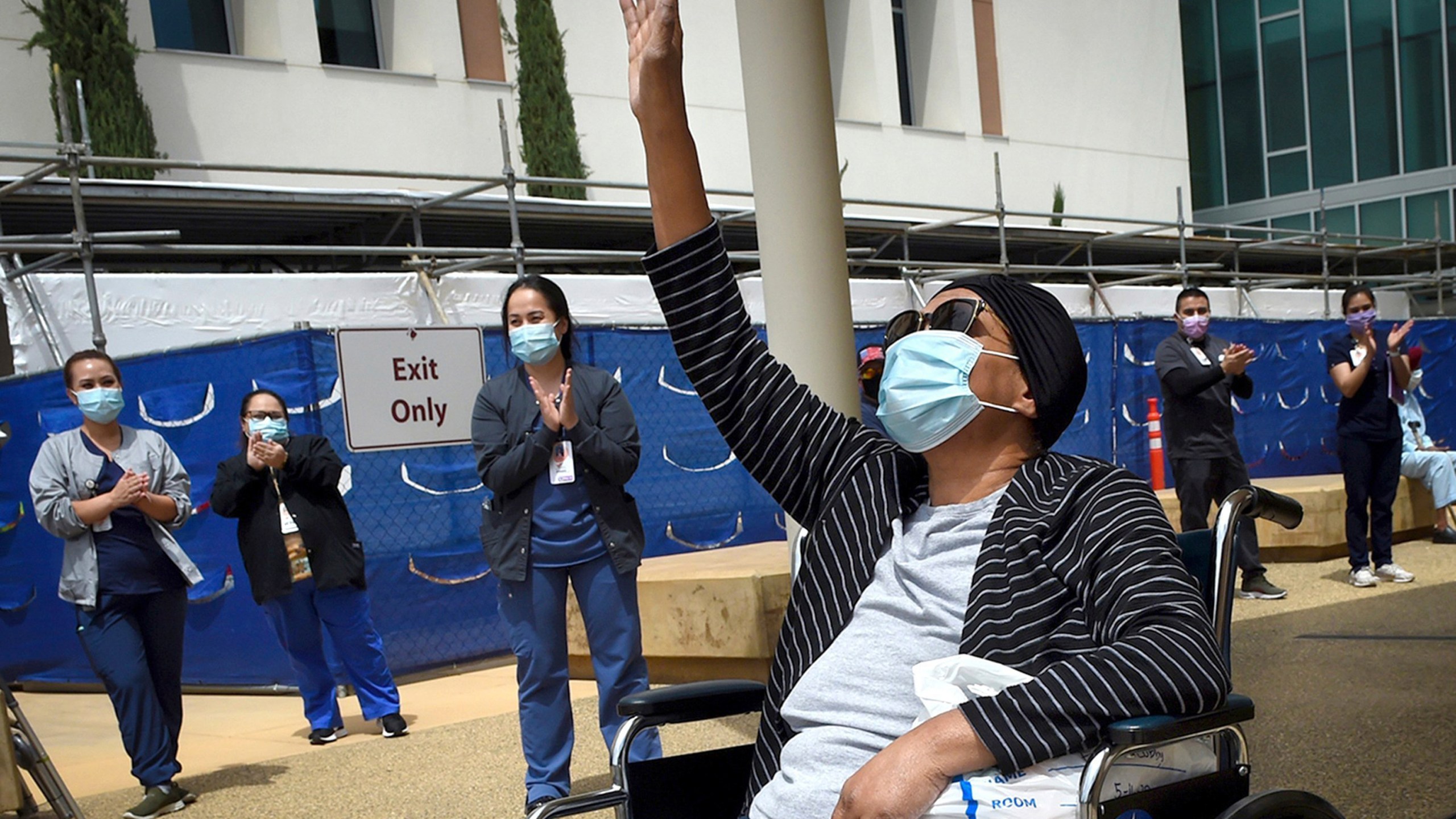 Karen Parker-Bryant, 64, raises a hand skyward after she was released from Clovis Community Hospital in Fresno after a battle with COVID-19 on May 19, 2020. (John Walker / The Fresno Bee via Associated Press)