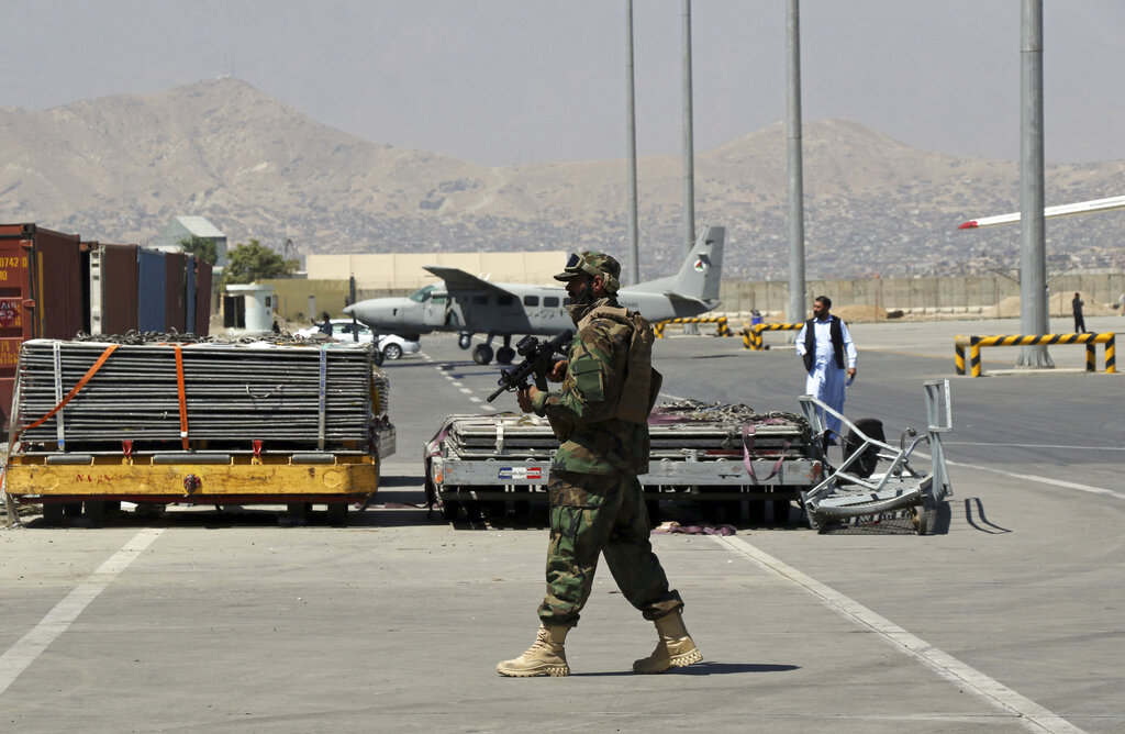 A Taliban soldier walks on the tarmac at Hamid Karzai International Airport in Kabul, Afghanistan, Sunday, Sept. 5, 2021. (AP Photo/Wali Sabawoon)