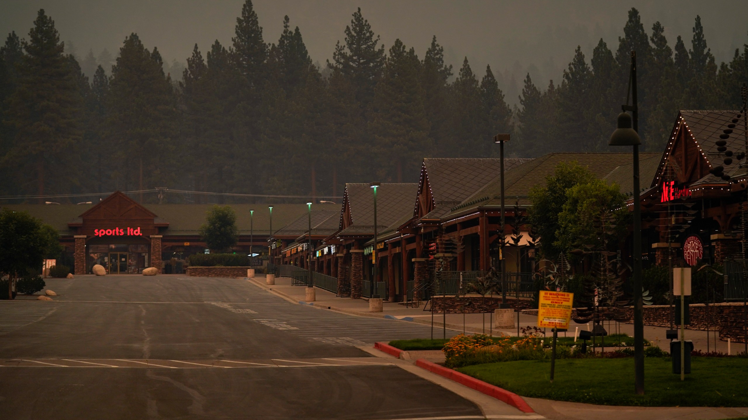 In this Tuesday, Aug. 31, 2021, file photo, a shopping mall is empty after a mandatory evacuation was ordered due to the Caldor Fire in South Lake Tahoe, Calif. State fire officials said evacuation orders for the area were reduced to warnings as of 3 p.m. on Sunday, Sept. 5. Some 22,000 people had been forced to flee the popular resort and nearby areas last week as the Caldor Fire roared toward it. (AP Photo/Jae C. Hong, File)