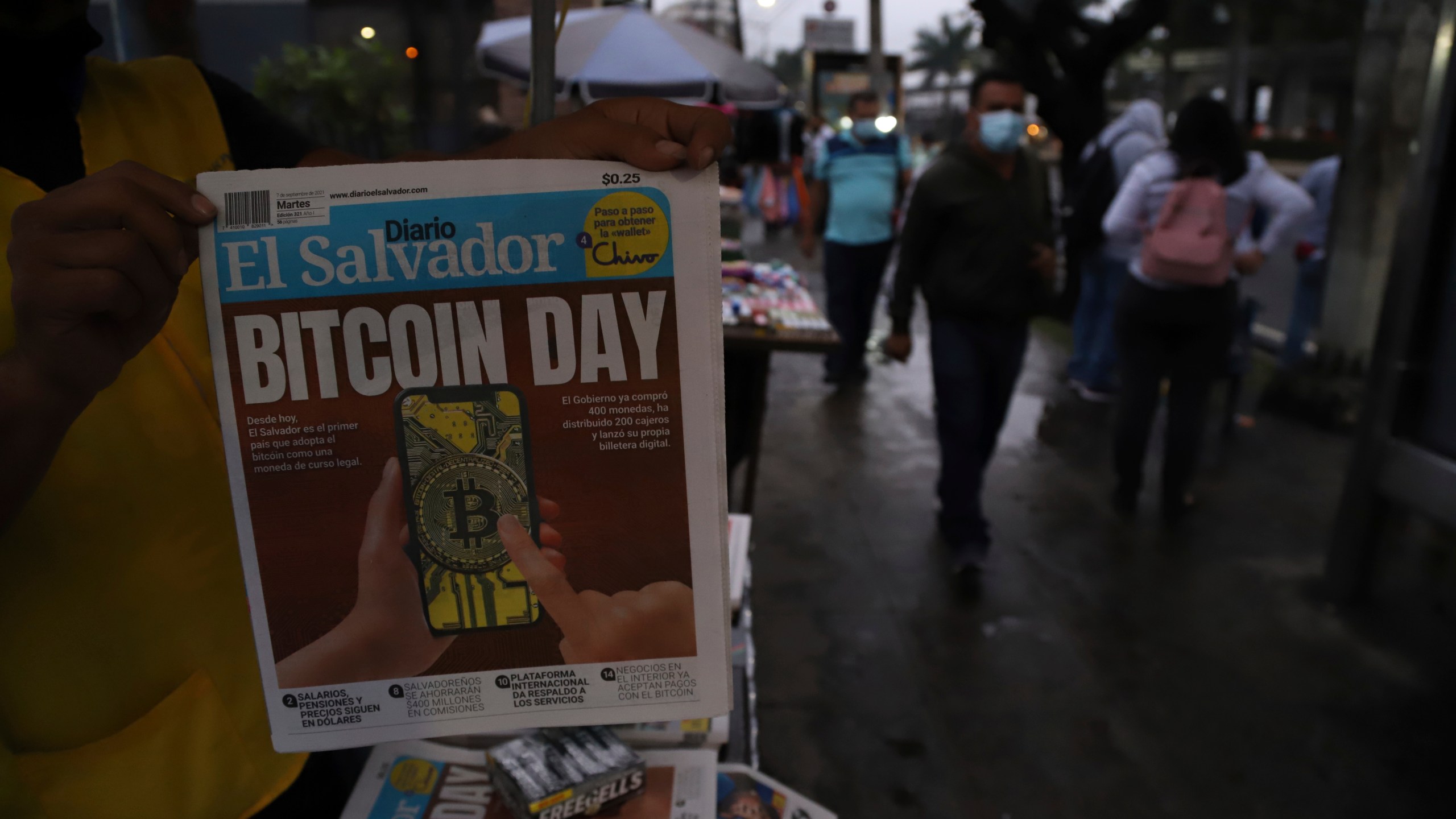 A newspaper vendor shows the front page of a state-run newspaper carrying the headline "Bitcoin Day" in San Salvador, El Salvador on Sept. 7, 2021. (Salvador Melendez/Associated Press)