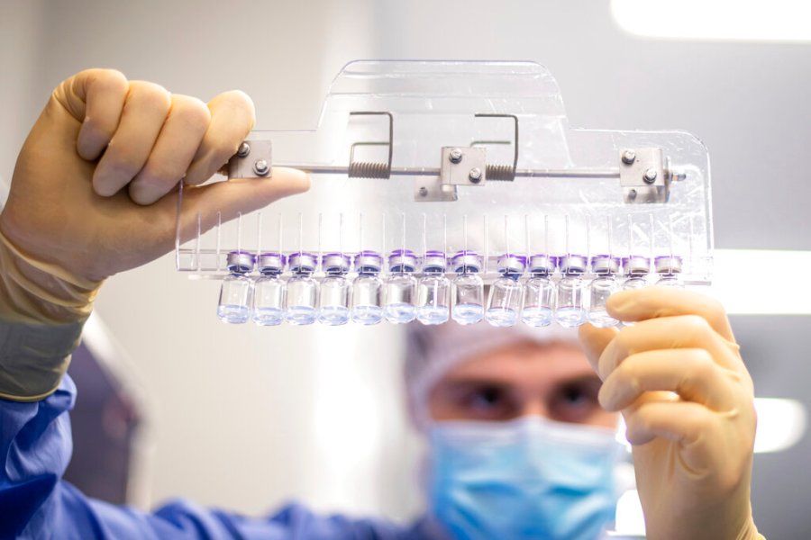 In this March 2021 photo provided by Pfizer, a technician inspects filled vials of the Pfizer-BioNTech COVID-19 vaccine at the company's facility in Puurs, Belgium. (Pfizer via AP)